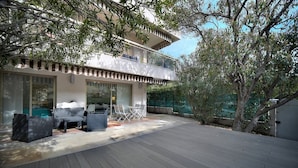 A modern two-story house with a balcony, outdoor seating area, and a wooden deck. - Upstays Terrace Garden 44m² Apartment (Cannes)