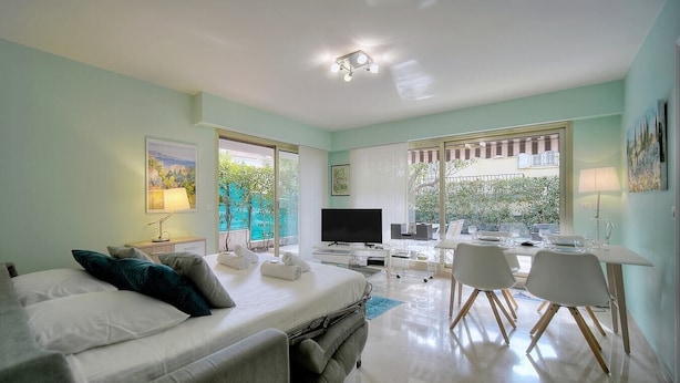 A modern bedroom with a bed, a desk, and a dining area. - Upstays Terrace Garden 44m² Apartment (Cannes)