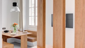 Un espace repas moderne avec une table en bois, des assiettes blanches et un vase rempli de fleurs.