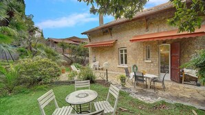 A stone house with a patio, outdoor seating, and lush greenery. - Upstays Terrace Garden 100m² Villa Center (Cannes)