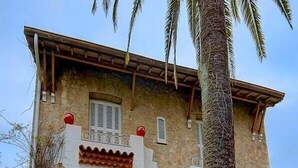 A two-story stone building with a balcony, a window with shutters, and a door with a small porch. - Upstays Terrace Garden 100m² Villa Center (Cannes)