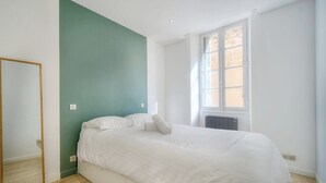 A bedroom with a bed, a mirror, and a window. - Immogroom-historic center-Fully equipped apartment - A/C - Wifi (Cannes)