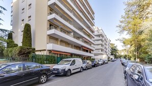 A multi-story hotel with balconies, parked cars, and a clear sky. - Upstays Croisette Terrace 35m² Apartment (Cannes)
