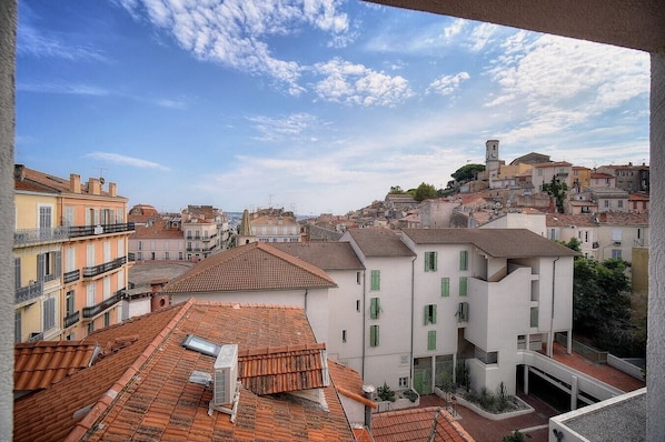 A view of a cityscape with buildings, including a prominent clock tower, and a clear sky. - Upstays Sea View 25m² Studio Suquet (Cannes)
