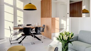 A modern dining area with a wooden table, black chairs, and yellow pendant lights. - Upstays Harbor View 45m² Apartment Palais (Cannes)