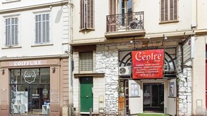 A building with a storefront labeled "Le Centre" offering services like massage and spa.
