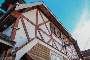 Un edificio con fachada de entramado tradicional, una señal de calle visible con el número 1020, y un letrero que indica 'E. diritto GENEVE'.