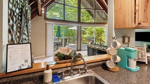 A kitchen with a large window, a sink, and a coffee maker. - 1 Min to Camelback! Creekside Escape + FirePit & BBQ (Tannersville)
