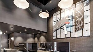 Un vestíbul modern amb un taulell de recepció, una escala i una paret gran amb un disseny d'hèlix d'ADN.