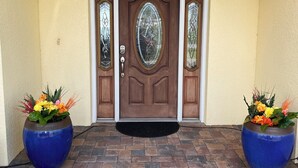 A brown door with glass panels, flanked by two large blue flower pots on a brick-paved entrance. - Disney and Universal Studios only 30 minutes away (Eagle Lake)