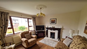 A living room with a fireplace, a television, and a sofa.