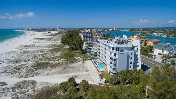 Et kysthotel med flere etager, en swimmingpool og udsigt til stranden.