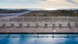 Una piscina con vista a la playa y las dunas.