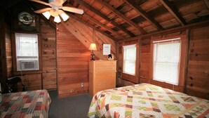 A cabin with two beds, a ceiling fan, a dresser, and a sign indicating 'SUMMER'.