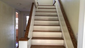 A staircase with wooden steps and white walls.