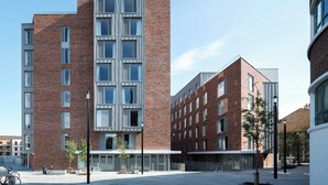 A modern multi-story building with a brick facade, large windows, and a flat roof. - Binary Hub (Dublin)