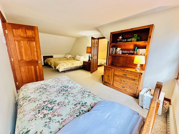 A bedroom with a bed, a dresser, and a bookshelf.