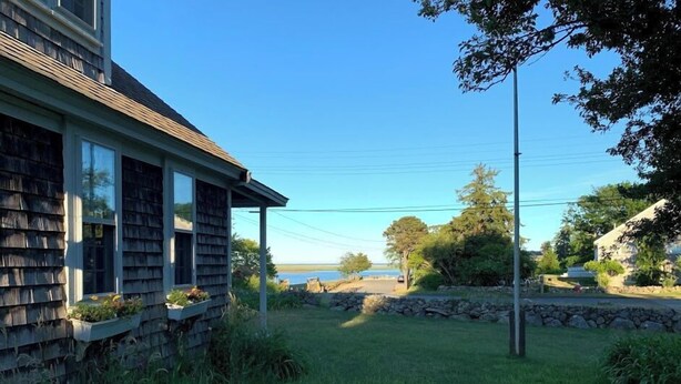 A house with a stone foundation, a wooden exterior, and a front porch. - Discover the charm of HEWORL: Tonset Treasure, (Orleans)