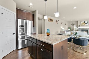 A modern kitchen with a stainless steel refrigerator, wooden cabinets, and a granite countertop. - PY1: Charming 4-bedroom house in Puyallup with WiFi, AC (Puyallup)