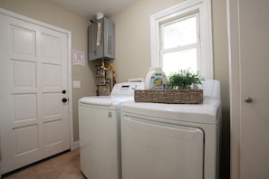 A laundry area with a washer and dryer, a water heater, and a window. - Sweet 5 Bedroom, 4 Bath Pool Home 1/2 Mile Walk To Disney (Anaheim)