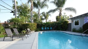 A swimming pool with lounge chairs, palm trees, and a building with a 'Diving' sign. - Sweet 5 Bedroom, 4 Bath Pool Home 1/2 Mile Walk To Disney (Anaheim)