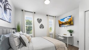 A modern bedroom with a bed, a desk, and a TV. - Cozy & Stylish/Pool Table & Fun

 (Camden)