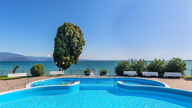 Ein Schwimmbad mit Blick auf das Meer und die Berge.