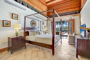 A four-poster bed with a wooden frame, a nightstand with a lamp, a dresser, and a television on a wooden desk. - Casa de Campo Modern Villa for Rent All-inclusive Ocean View Villa With Chef Butler Maid (La Romana)