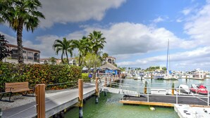 A marina with boats docked, a wooden pier, and palm trees. - Beautiful one bedroom condo in Marco Island with so much to offer!  (Marco Island)