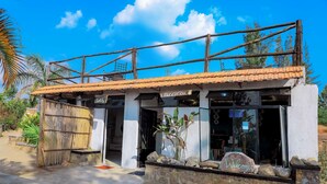 A reception area with a sign reading "Reception," a wooden fence, and a stone wall with a "Welcome" sign. - Banana Eco Resort (Kiziguro)