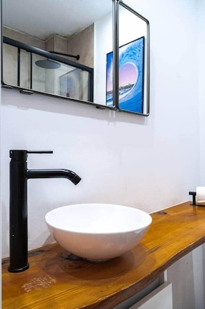 A bathroom with a white sink, black faucet, and a mirror above it. - Apartamento Recién Reformado en las 4 Torres + IE (Madrid)