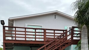 A two-story building with a wooden staircase leading to a covered garage. - Waterfront Everglades basecamp with dock, trailer parking, and direct bay access (Ochopee)