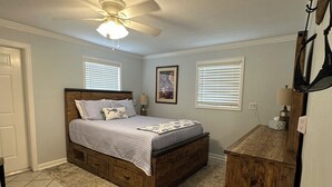A bedroom with a bed, a ceiling fan, a desk, and a chair. - Waterfront Everglades basecamp with dock, trailer parking, and direct bay access (Ochopee)