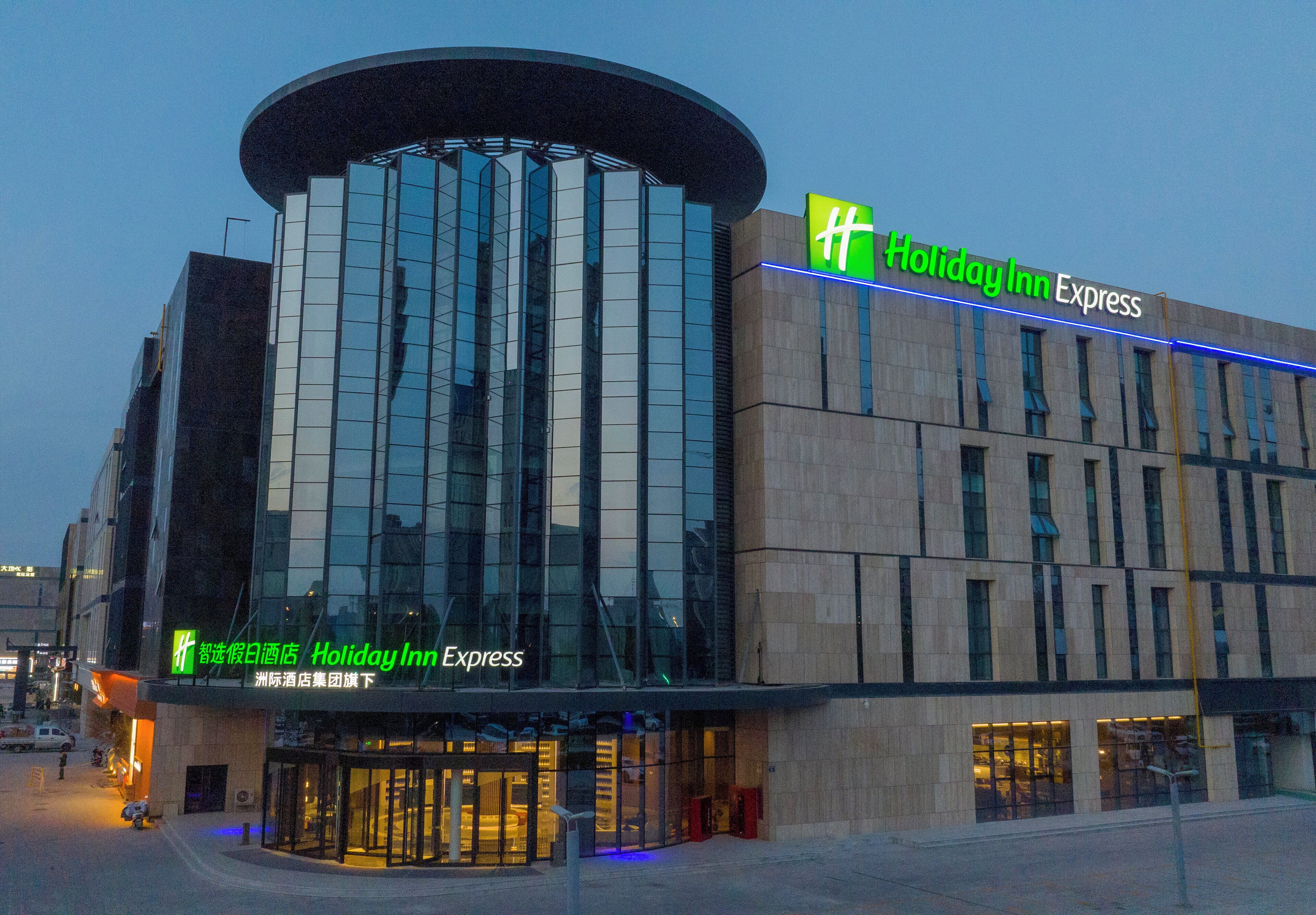 A Holiday Inn Express building with a modern glass facade and a prominent sign.
