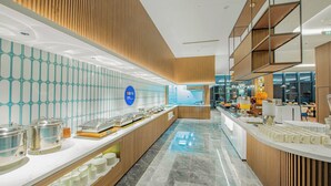 A modern breakfast area with a long counter, glassware, and a blue sign indicating a buffet. - Holiday Inn Express Yinchuan Lanxi Valley Plaza by IHG (Yinchuan)