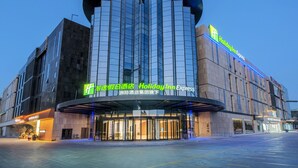 A Holiday Inn Express hotel with a modern glass facade and a curved entrance. - Holiday Inn Express Yinchuan Lanxi Valley Plaza by IHG (Yinchuan)