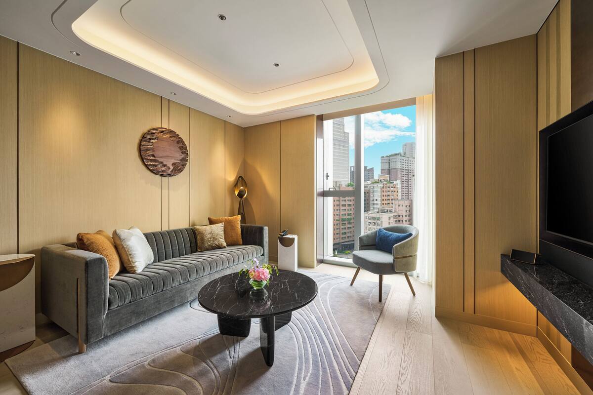 Una sala de estar moderna con un sofá, un sillón y un televisor de pantalla plana.
