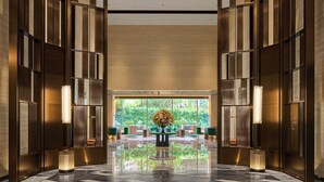 A spacious lobby with a large, intricate chandelier, wooden paneling, and a reflective floor. - Intercontinental Taichung by IHG (Taichung)