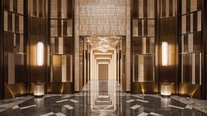 A long, narrow hallway with a reflective marble floor and vertical paneling on the walls. - Intercontinental Taichung by IHG (Taichung)