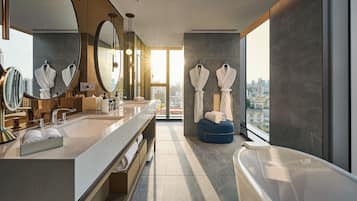 A modern bathroom with a large mirror, dual sinks, a bathtub, and a city view.