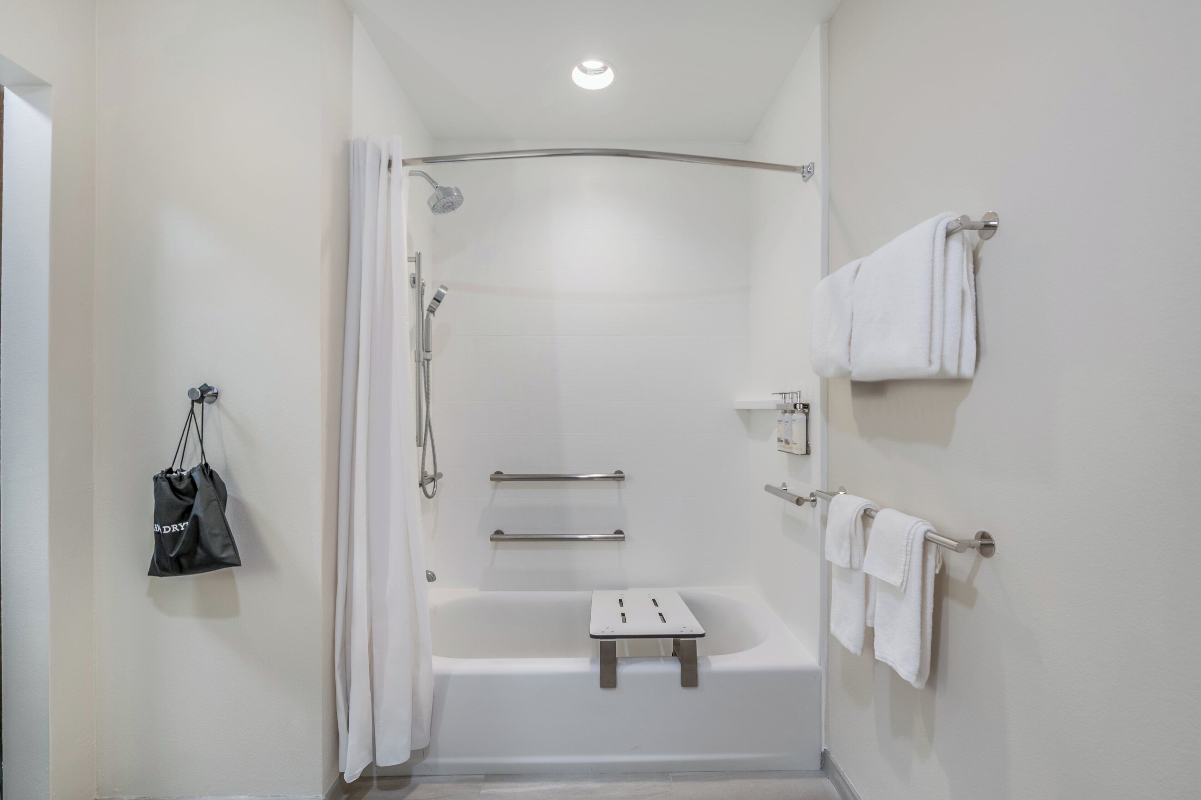 A modern bathroom with a shower, a bathtub, and a towel rack.
