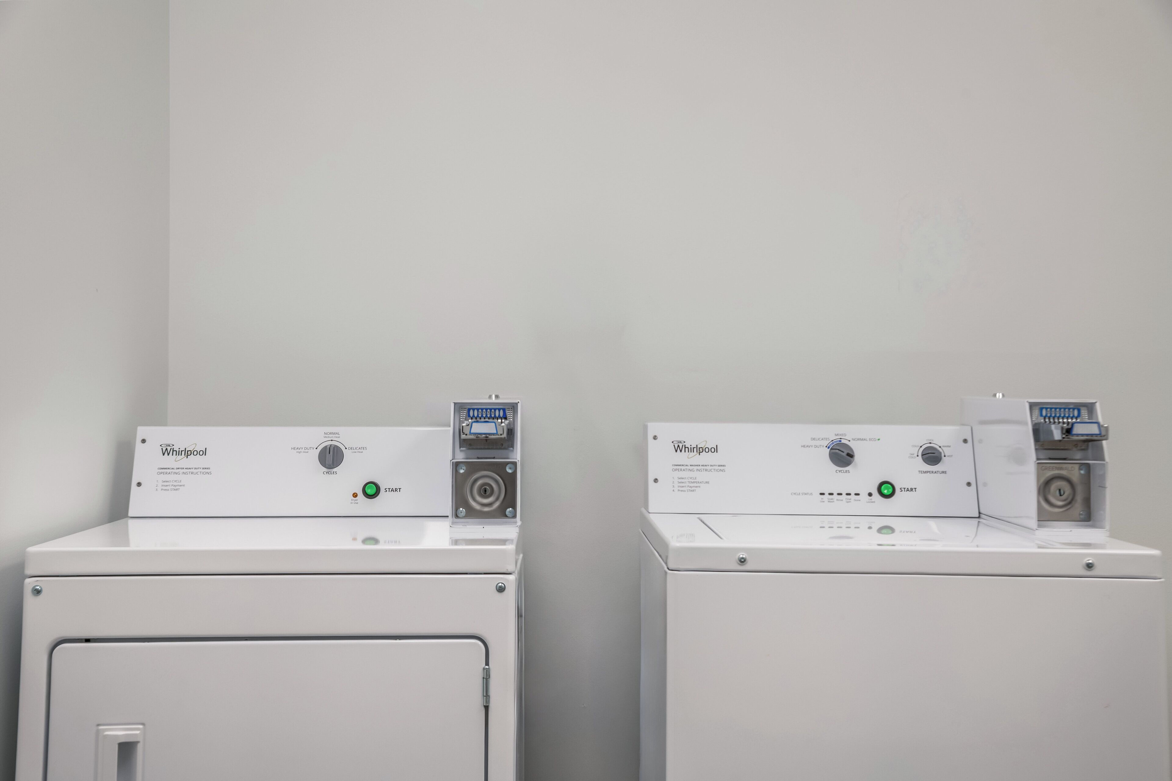 Two Whirlpool washing machines with operating instructions and cycle selection buttons.
