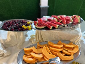 A fruit display with various fruits including watermelon, grapes, and cantaloupe. - Villaggio Stella Maris (Giugliano in Campania)