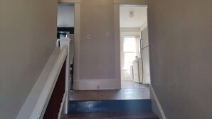 Una escalera conduce a un segundo piso donde se ve un área de cocina.