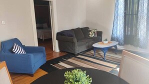 Un salón con sofá, una mesita de centro y una planta en maceta.