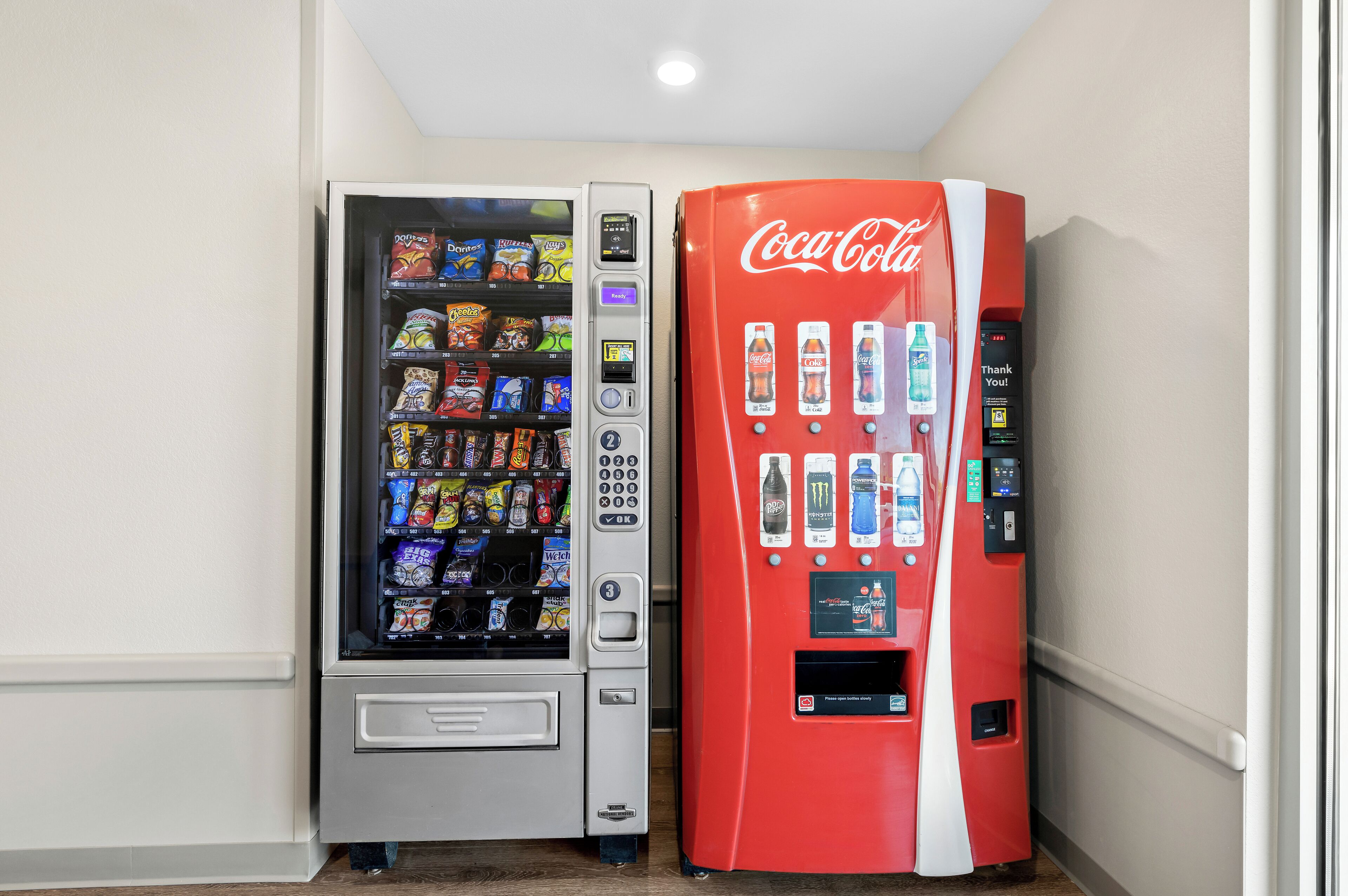 A vending machine with snacks and a Coca-Cola machine.