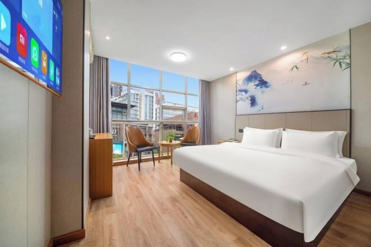 Quarto de hotel com uma cama grande, uma mesa e uma cadeira.