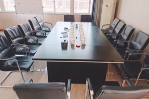 Ett konferensrum med ett långt bord och stolar placerade runt omkring.