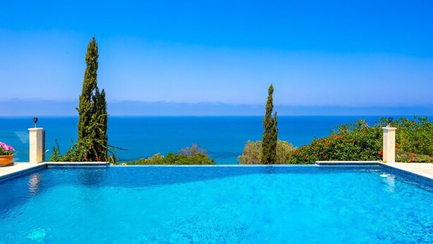 Un cielo azul despejado y una piscina con vistas al mar.