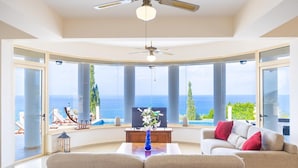 Amplia sala de estar con un gran ventanal con vistas al mar y un balcón.
